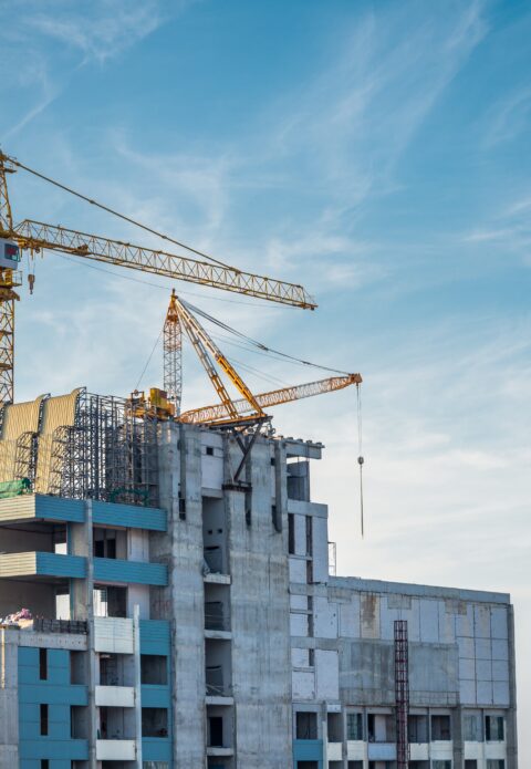 Modern building condominium under crane construction against blue sky - Bangkok Thailand